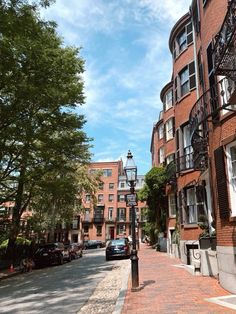 a car parked on the side of a street next to tall brick buildings with balconies