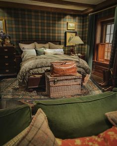 a large bed sitting next to a green couch in a room with plaid walls and furniture