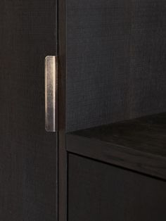 a close up of a black cabinet with a metal handle on it's door