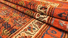 an orange rug with many different colors and patterns on it's sides, in close up