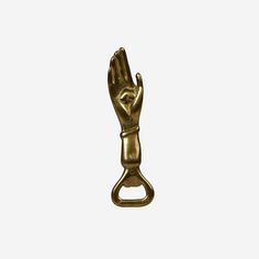 a gold colored metal object with a hand on it's side, against a white background