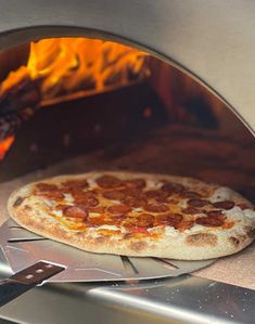 a pizza is cooking in an oven with flames coming from the back and on top