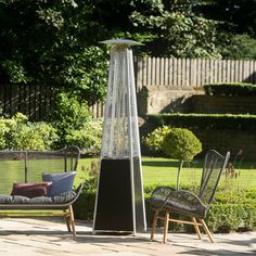 an outdoor patio area with two chairs and a fire pit in the middle of it