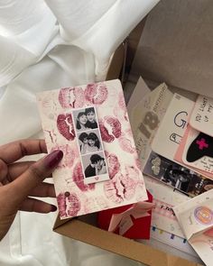 someone is holding up a card with pictures on it and other items in the background