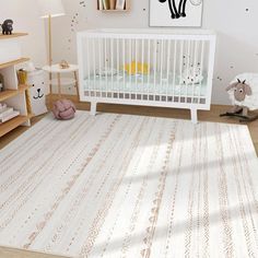 a baby's room with a white crib and rug