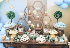 a dessert table with cupcakes, cookies and other treats on top of it