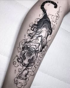 a black and white tiger tattoo on the arm