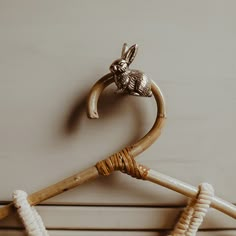 a wooden coat hanger with a metal rabbit head on it's back end