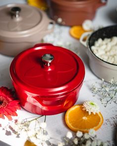 a red casserole dish sitting on top of a table next to other dishes