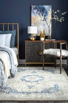 a bedroom with dark blue walls and white bedding, an antique sideboard, gold accents and a painting on the wall