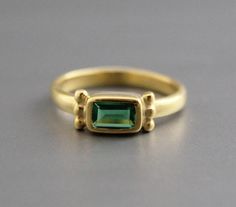 Classic Gold Tourmaline Jewelry, Gold Tourmaline Ring For May Birthstone, Gold Rings With Tourmaline Gemstone Accents, Gold Tourmaline Rings With Gemstone Accents, Classic Gold Tourmaline Rings, Modern Gold Emerald Ring With Accent Stones, Classic Tourmaline Jewelry For May Birthstone, Classic Emerald Ring With Gemstone Accents, Classic Yellow Gold Sapphire Ring With Gemstone Accents