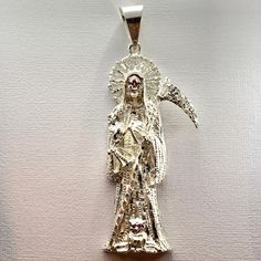 This elegant pendant features the image of the La Santa Muerte surrounded by rays of light. Comes in 925 sterling silver. Unique jewel is our exclusive design. Pendant Height: 3 inch Mystical Silver Pendant Jewelry, Spiritual Sterling Silver Halo Jewelry, Spiritual Sterling Silver Jewelry With Halo Detail, Mystical Engraved Silver Jewelry, Silver Pendant Jewelry With Shiny Finish, Sterling Silver Jewelry With Halo Detail, Sterling Silver Halo Jewelry In Silver, Silver Halo Round Pendant Jewelry, Collectible Silver Spiritual Jewelry