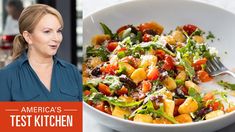 a woman standing next to a white bowl filled with food and the words america's test kitchen