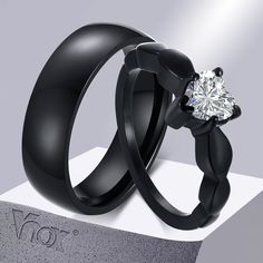 two black wedding rings with a diamond in the middle