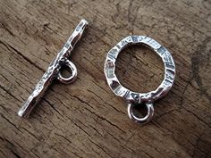 two silver metal rings sitting on top of a wooden table