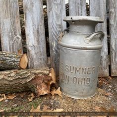 an old metal container sitting in front of a wooden fence