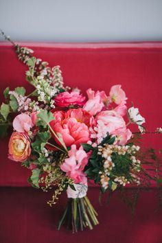 a bouquet of flowers sitting on top of a red couch