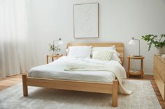 a bed with white linens and pillows in a bedroom next to a wooden dresser