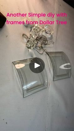 two clear glass containers sitting on top of a white cloth covered table with chains attached to them