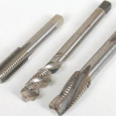 four different types of screws on a white surface