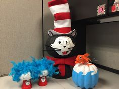 the cat in the hat is sitting next to two pumpkins and an odd thing