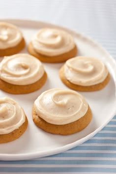 several cookies with frosting on a white plate