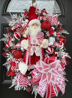 a christmas wreath with santa claus and candy canes hanging on the front door,