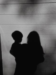 the shadow of a woman and child against a wall