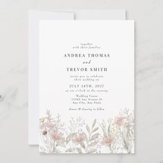 an elegant floral wedding card with watercolor flowers and greenery on the front, in white