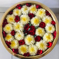 red and white flowers in a gold bowl