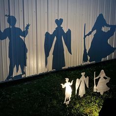 three silhouettes of people standing in front of a wall with the shadow of two men and one woman