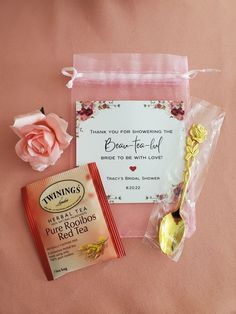 a couple of items that are laying out on a pink surface with flowers and a card