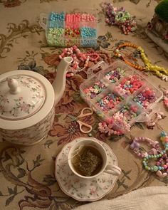 a tea pot and some beads on a table