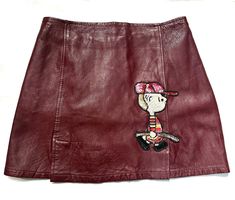 Super cute burgundy leather skirt made in Italy in the 80s, with a sweet Charlie Brown hand embroidery of sequins and glass beads to the front/right.  Skirt is part of a deadstock, used just for display and in perfect condition. sz 42 ITA, M waist 71 cm Length 38 cm Size M Burgundy Leather Skirt, Character Embroidery, Leather Miniskirt, Peanuts Characters, Brown Hand, Charlie Brown Peanuts, Long Sleeve Polo Shirt, Leather Mini Skirts, Cherry Red