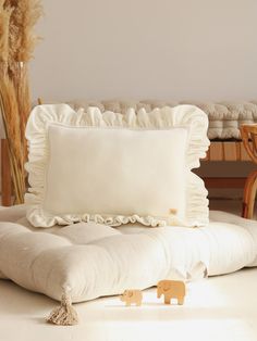 a white pillow sitting on top of a couch next to a wooden toy elephant figure