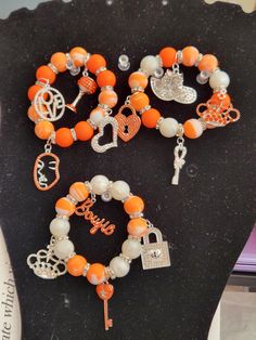 -Three Stack Stretchable Charm Bracelet -Each bracelet has four silver and orange bling charms -Beads are 15mm -Put bracelets on carefully by gently rolling them onto the wrist -Can be worn altogether or separately Personalized Orange Round Bead Jewelry, Personalized Orange Bracelets With Round Beads, Personalized Orange Bracelets As Gift, Adjustable Nickel-free Orange Bracelets, Adjustable Nickel-free Orange Bracelet, Orange Bangle Stretch Bracelet For Gift, Jewelry Fashion Trends, Charm Bracelets, Bead Charms