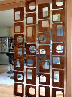 an open glass door with wooden squares and circles on it in front of a dining room table