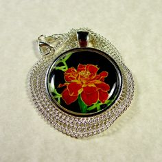 This marigold pendant features my watercolor painting depicting a orange and yellow flower against a black background in a 1-inch silver-tone setting. The original painting resides in my studio. The image is protected by an epoxy cabochon. Includes a 20-inch curb link chain with a lobster claw clasp. It was painted as October in a calendar of birth month flowers. My grandmother used to plant marigolds around the border of her vegetable garden to keep the rabbits out. My high school colors were o Marigold Wedding, Pom Mom, Violet Wedding, Golden Retriever Mom, Perfect Music, Month Flowers, Mothers Day Gifts, Birth Month Flowers, Orange And Yellow