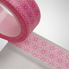 a roll of pink washi tape sitting on top of a white surface