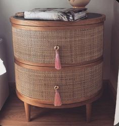 a wooden cabinet with two drawers and tassels