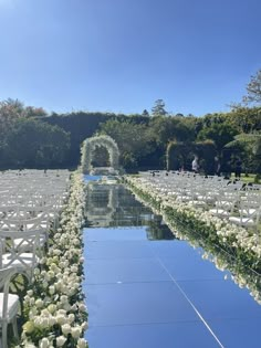 an outdoor ceremony with rows of chairs and white flowers