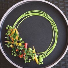 a black plate topped with peas and carrots