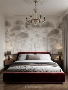 a bedroom with a bed, chandelier and wallpaper in the background that has trees on it