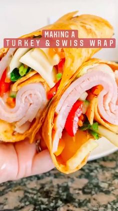 a hand holding a wrap filled with meat and veggies