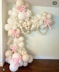 balloons and bows are arranged in the shape of an x on top of a wall