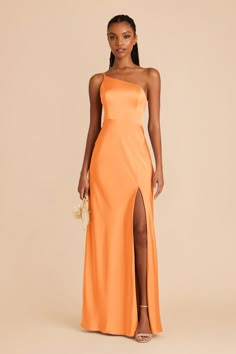 a woman wearing an orange dress with one side slit