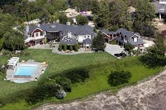 an aerial view of a large house with a swimming pool in the middle of it