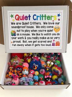 a box filled with lots of colorful little monster toys next to a sign that says quiet critters we are quiet critters