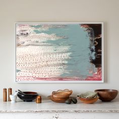 a painting hanging on the wall next to bowls