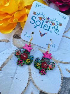 "Lightweight and comfortable, these earrings effortlessly blend traditional charm with modern flair. The hand-painted details add a touch of personality and authenticity, ensuring that you carry a piece of Mexico's artistic soul with you wherever you go. Length: 1.5\" These beautiful earrings are hand painted on wood.  Every piece is completely unique because of the detailed process that goes into creating it.  The black lacquer is created by mixing in layers of dirt with a grease from the Cochi Earrings Boho Chic, Boho Chic Earrings, Mexican Jewelry, Traditional Mexican, Chic Earrings, Black Lacquer, Earrings Boho, Floral Earrings, Earrings Dangle